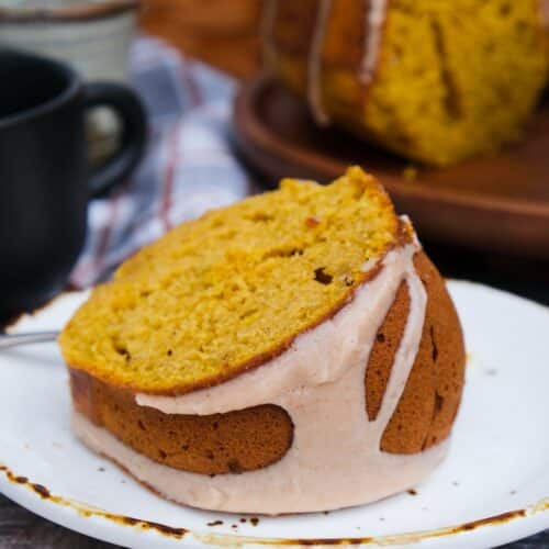 A slice of pumpkin spice bundt cake on a white plate.