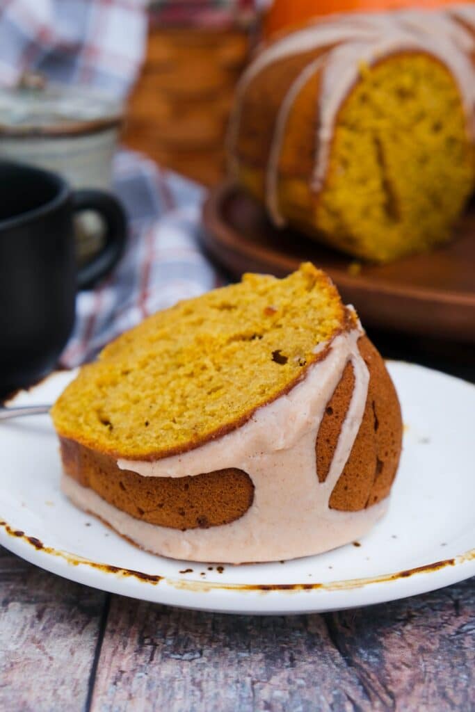 A slice of pumpkin spice bundt cake on a white plate.