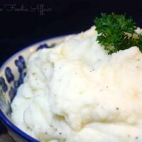Fluffy Whipped Potatoes in a serving bowl topped with parsley