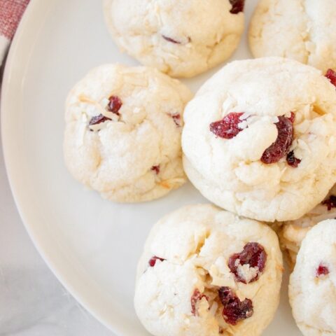 A top view of cranberry cookies on a white plate ready to eat.