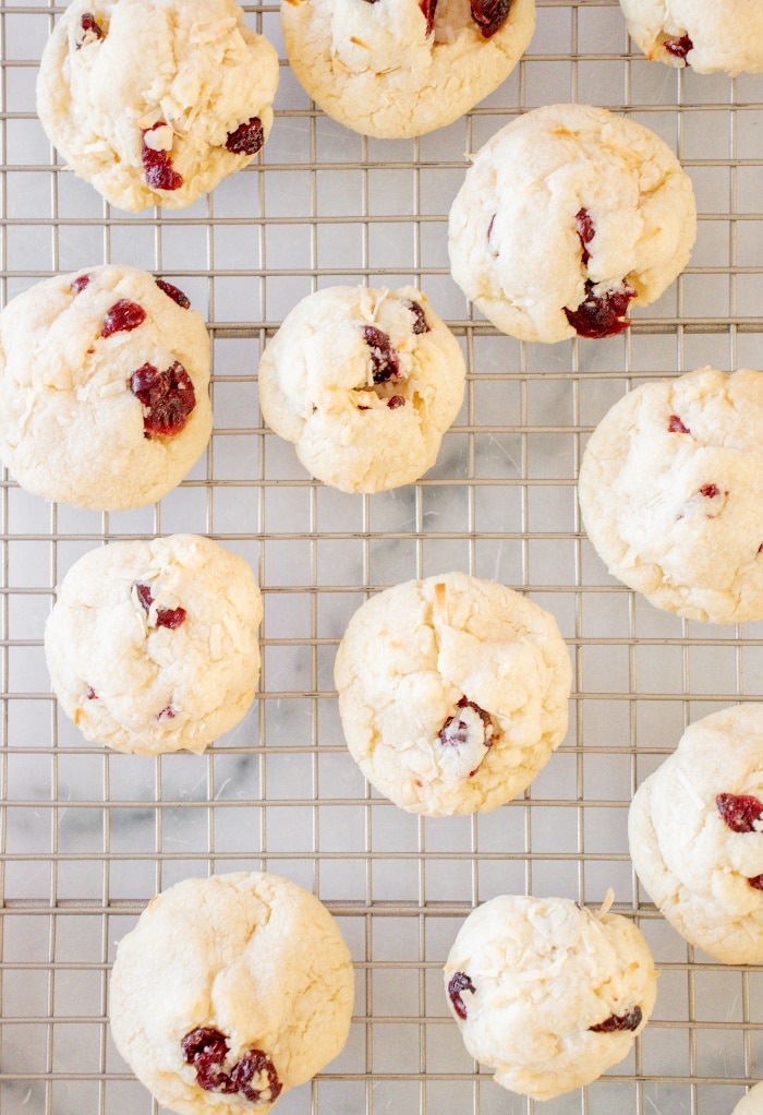 A top view of cranberry cookies cooling on a cooling baking rack.