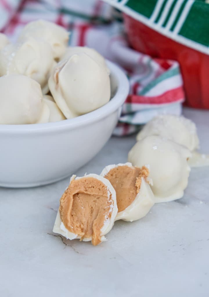 A peanut butter snowball sliced in half showing the center peanut butter filling. 