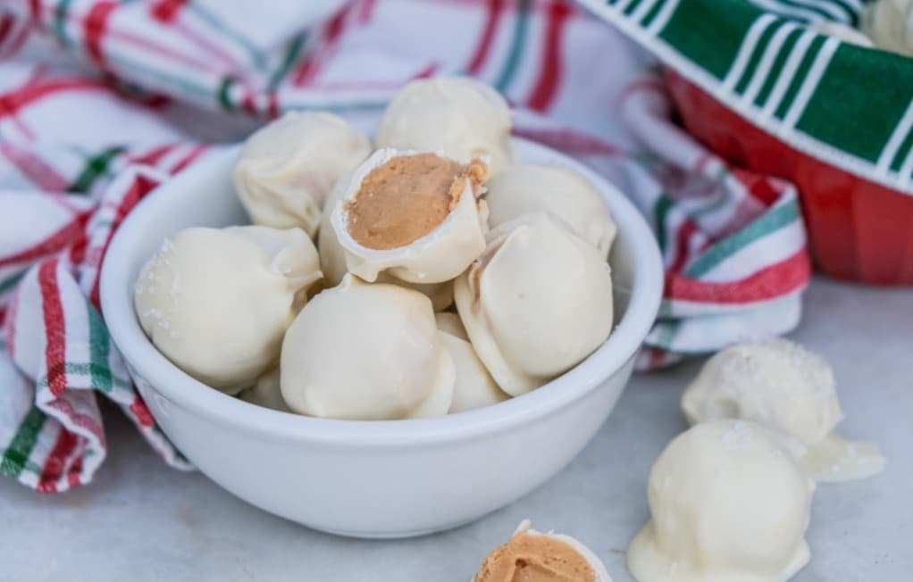 No bake peanut butter snowballs in a white serving dish.