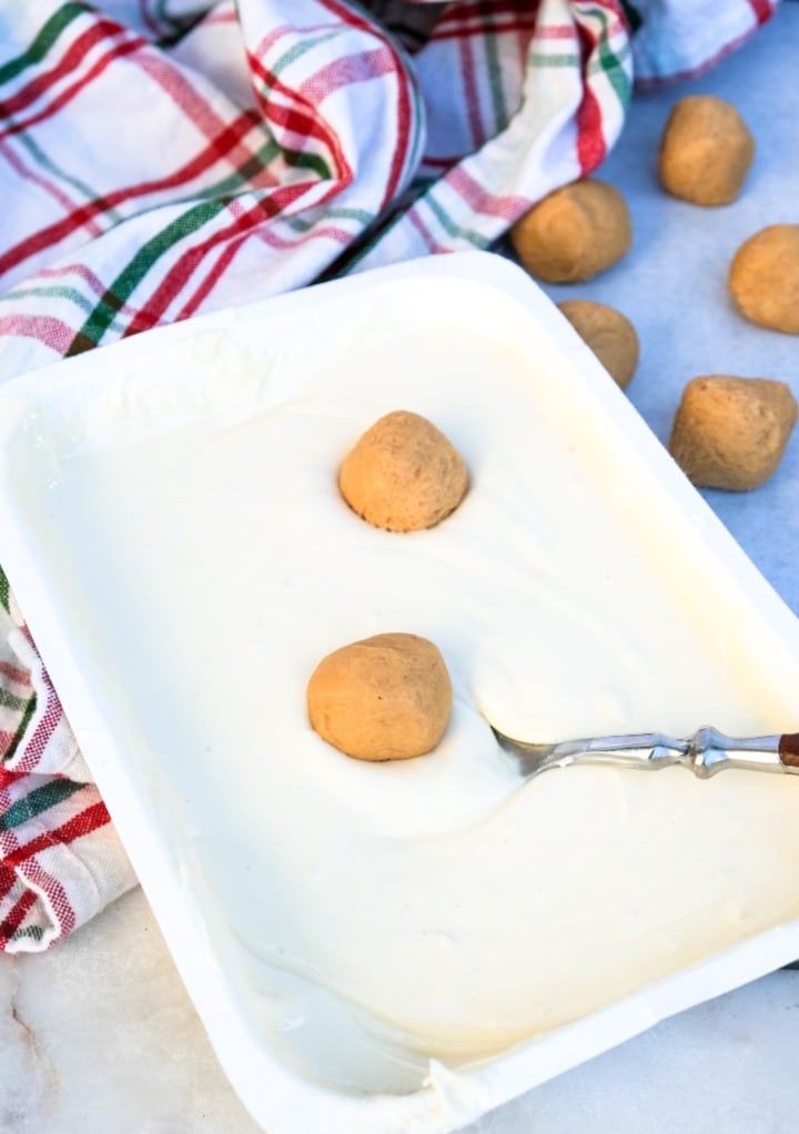 Peanut butter snowballs in melted almond bark.