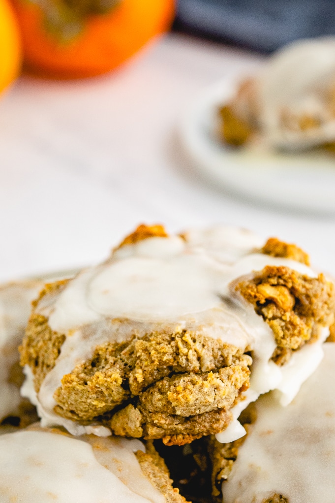 Close view of baked persimmon cookie topped with glaze. 