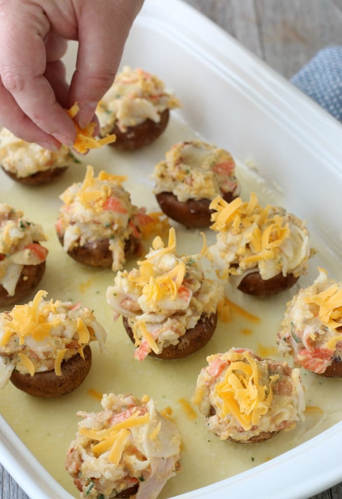 The final touch for these stuffed mushroom with crab filling is to add the cheese on top!