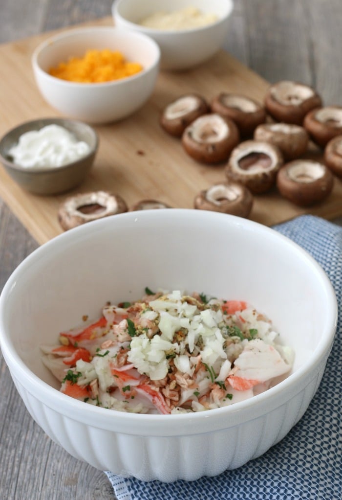 This image shows the stuffed mushroom with crab mixture being combined and ready to be stuffed into mushroom caps. 