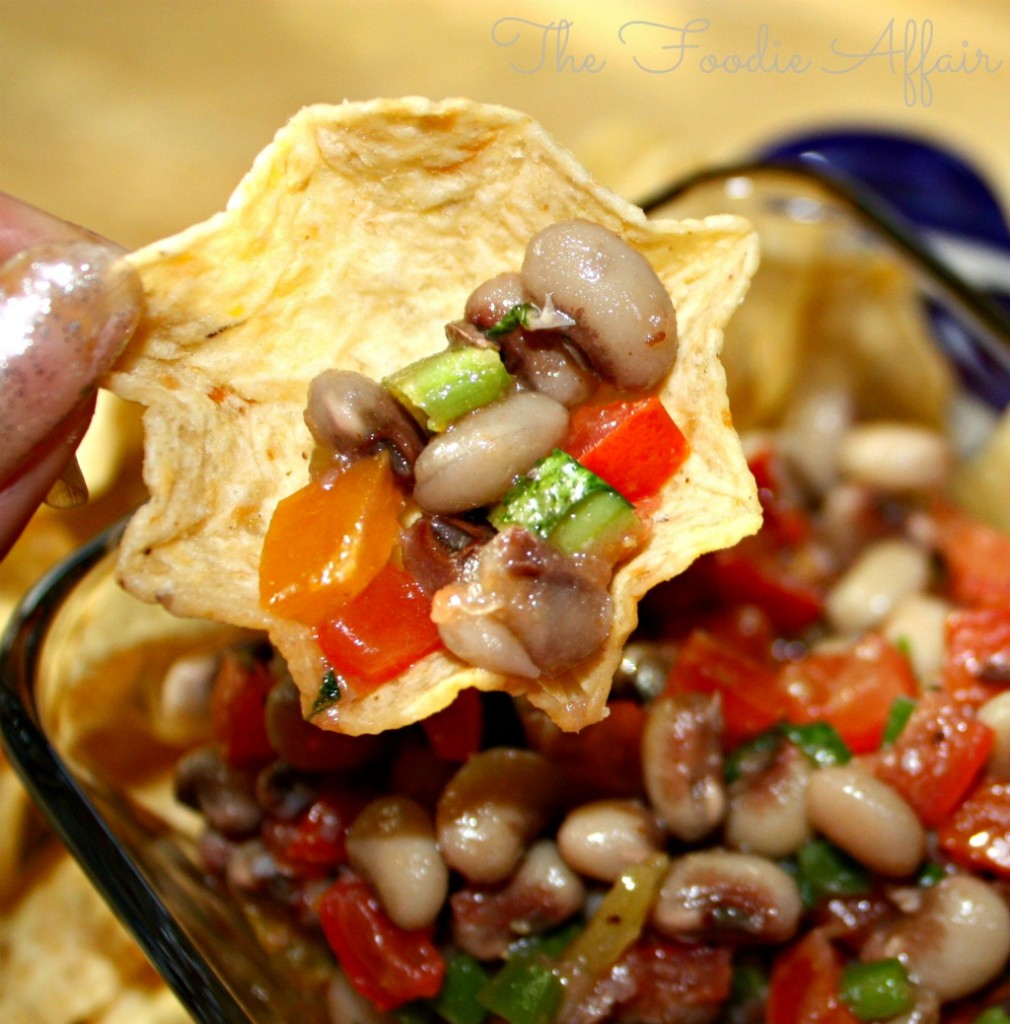 a scoop tortilla chip with Texas caviar dip