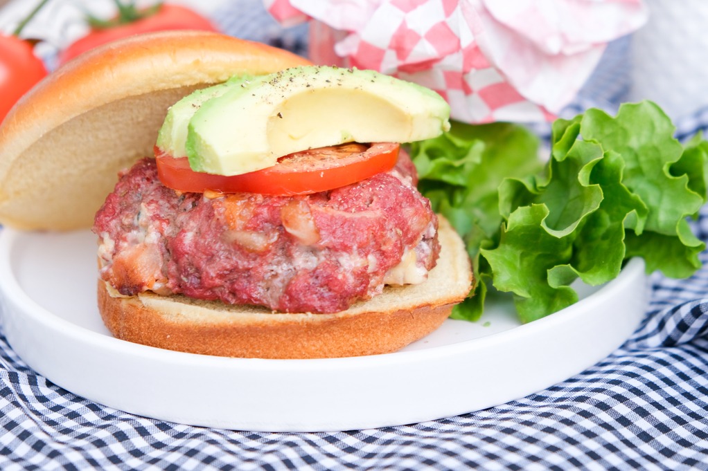 Cooked hamburger patty on a serving plate ready to add condiments. 