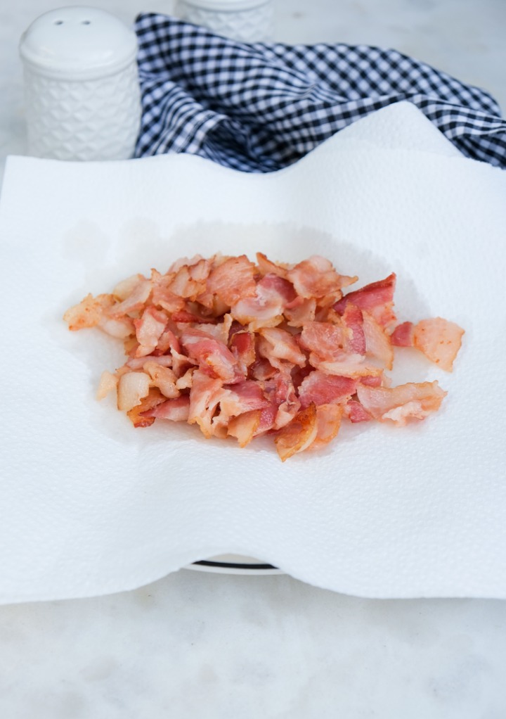 Cooked bacon draining on paper towels. 