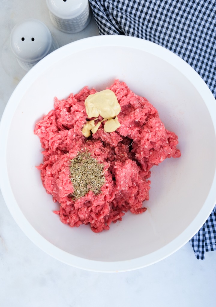 Ground beef with spices before mixing to make hamburgers. 