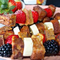 French Toast Kabobs with fruit on a pink platter