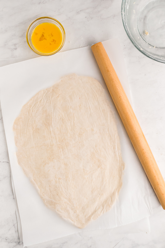 Rolled pie dough between parchment paper. 