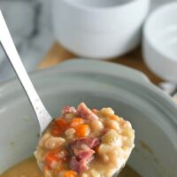 A ladle full of the ham and bean soup is ready to be dished out and enjoyed.