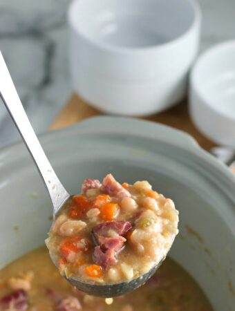 A ladle full of the ham and bean soup is ready to be dished out and enjoyed.