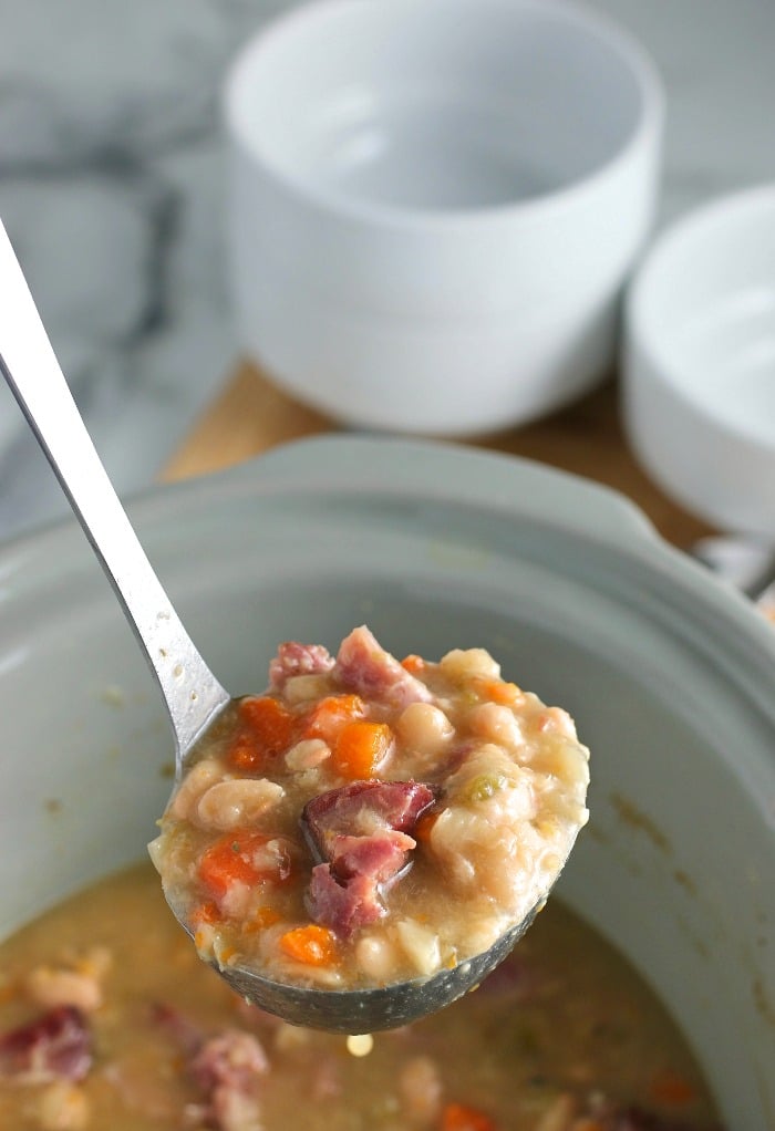 A ladle full of the ham and bean soup is ready to be dished out and enjoyed. 