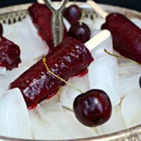 Cherry Limeade Popsicles on a tray filled with ice