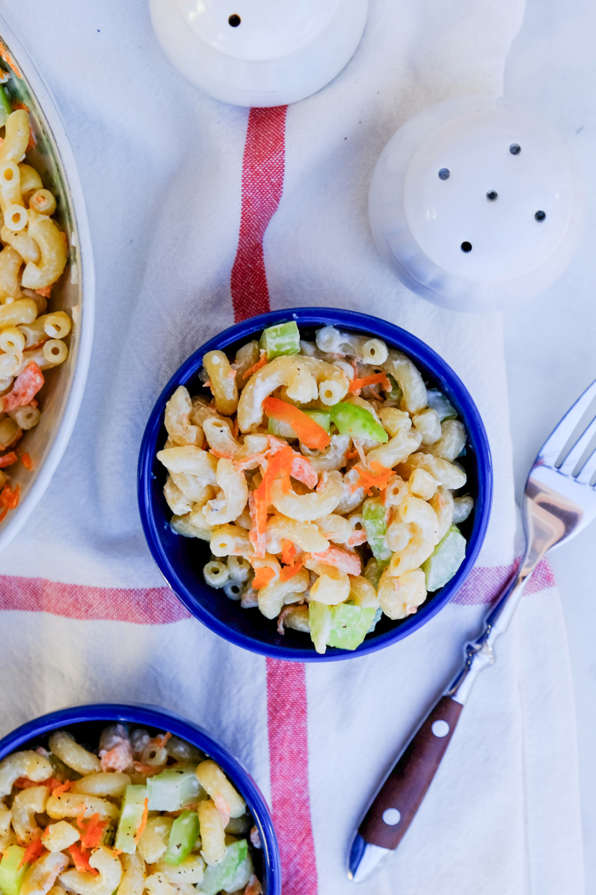 Top view of pasta salad in small blue serving dishes. 