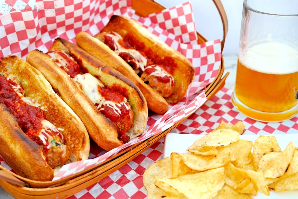 Turkey Meatball Subs in a basket ready to enjoy with a beer on the side. 
