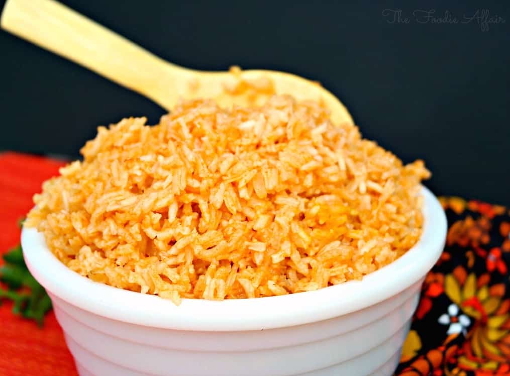 Spanish rice in a white bowl with wooden spoon