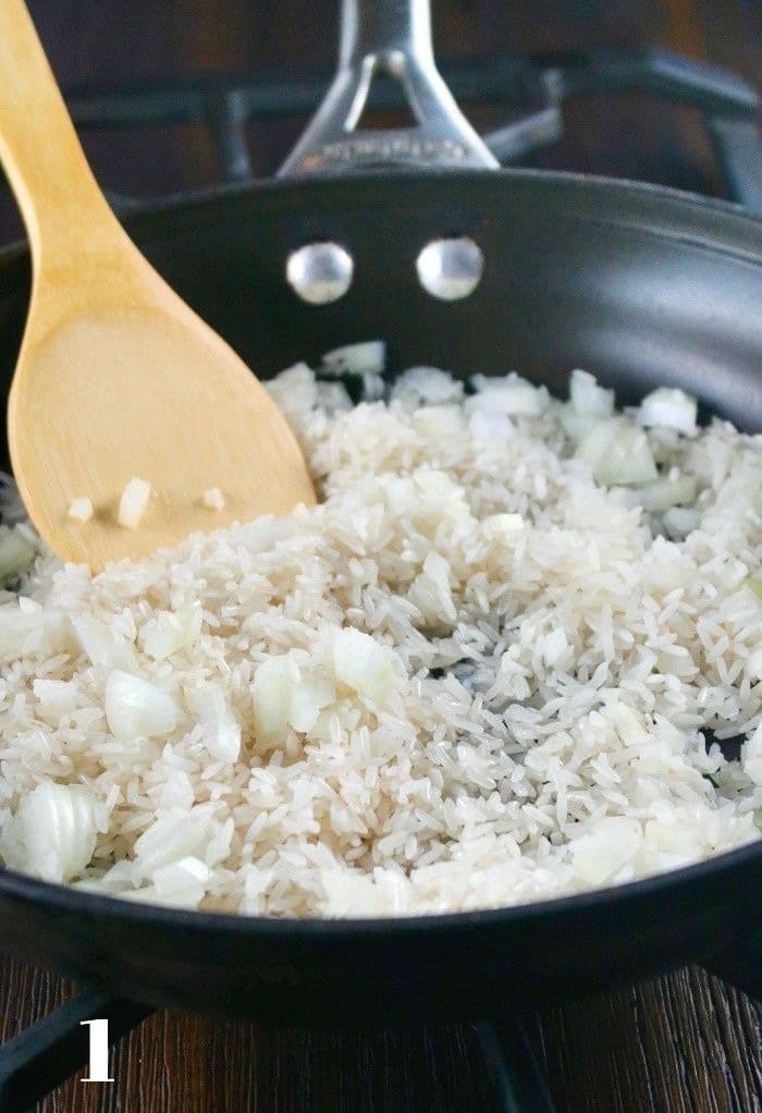 Sautéing spanish rice and onion in a skillet. 