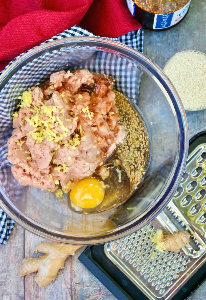 Ingredients for teriyaki burgers in a large clear mixing bowl