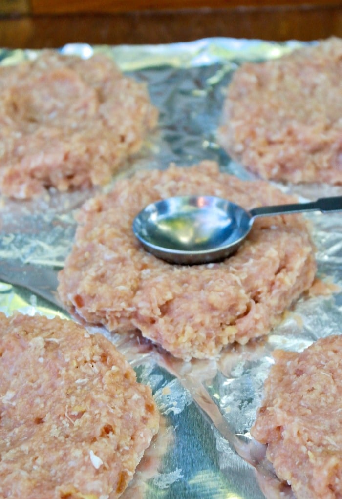 Form turkey burgers and placed on a baking sheet with a small indentation in the center of each burger. 