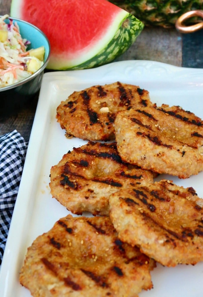 A white platter of cooked teriyaki burgers