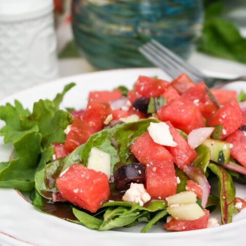 Green salad topped with watermelon and feta cheese.