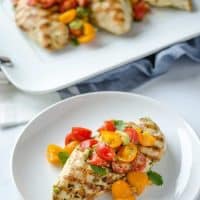 grilled chicken and avocado salsa on a white plate