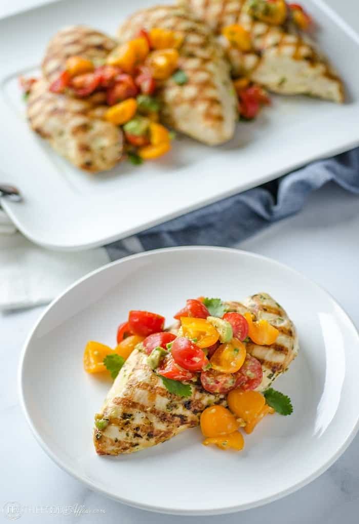 grilled chicken and avocado salsa on a white plate