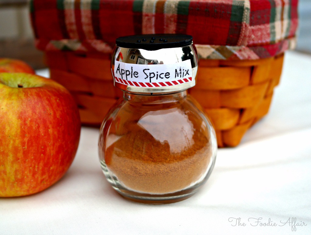 Homemade Apple Pie Spice Mix in a glass jar with a fresh apple on the side