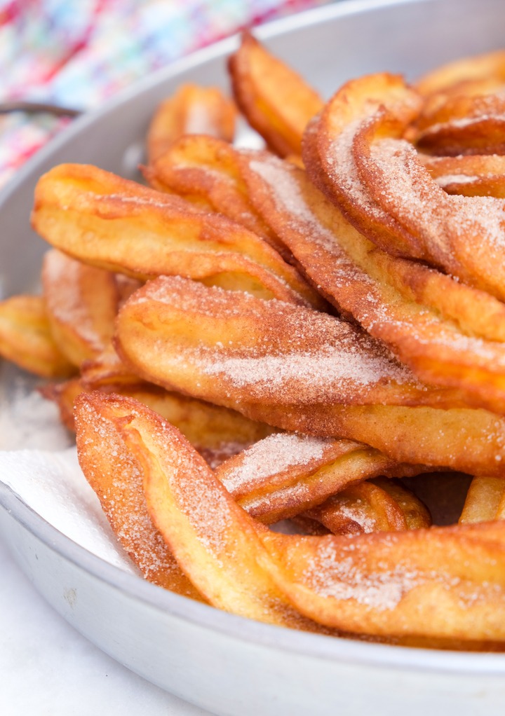 Homemade churros on paper towels on a serving dish. 