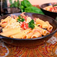 Italian Sausage Rigatoni in a brown pasta bowl topped with fresh basil.