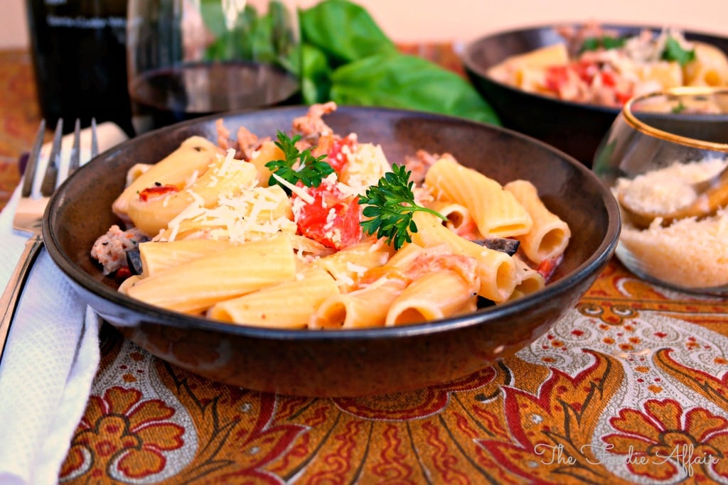 Italian Sausage Rigatoni in a brown pasta bowl topped with fresh basil.