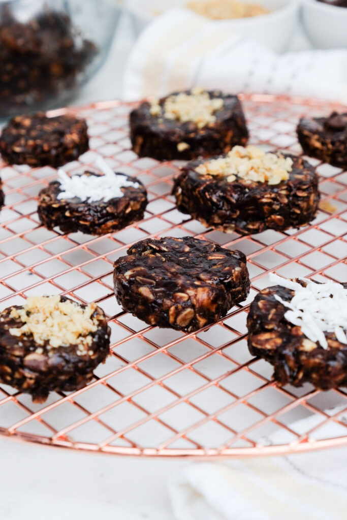 No-bake cookies on a cooling rack topped with coconut and nuts. 