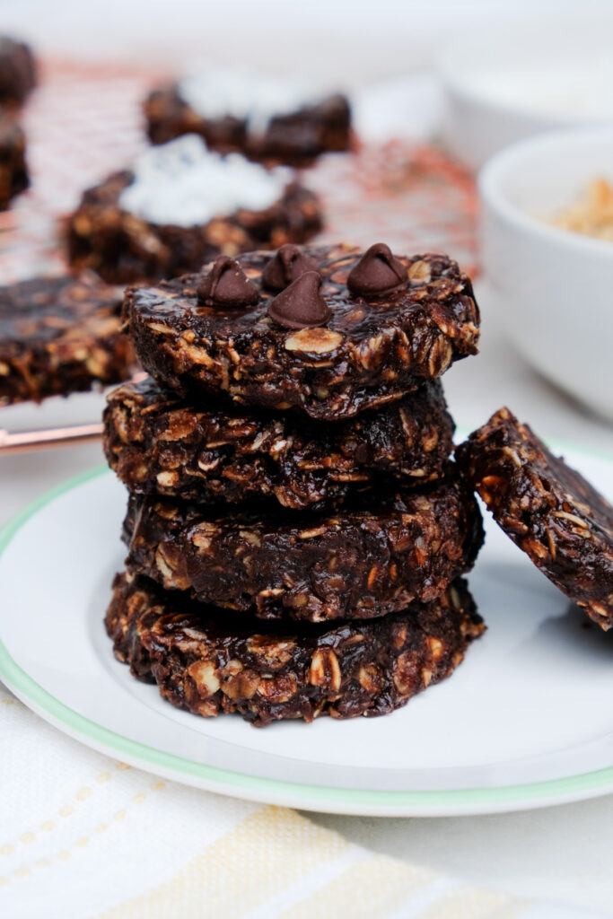 No bake chocolate oatmeal cookies on a white plate with a green rim. 