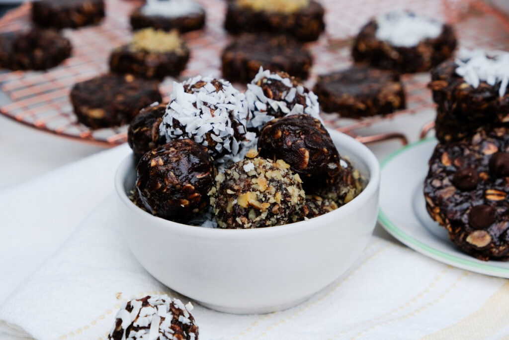 no bake peanut butter oatmeal balls with coconut and nuts in a small white bowl. 