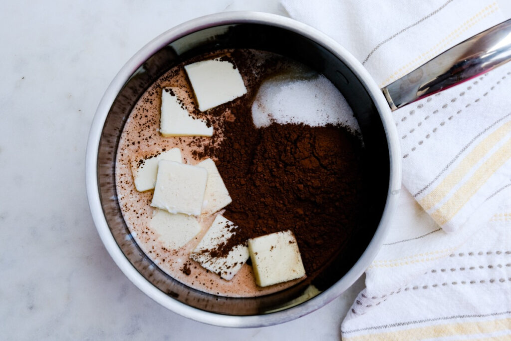 Butter, oatmeal, cocoa powder, and sugar in a saucepan.