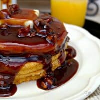 Pumpkin Pancakes with Pecan Maple Syrup on a white plate