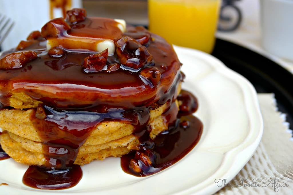 Pumpkin Pancakes with Pecan Maple Syrup on a white plate