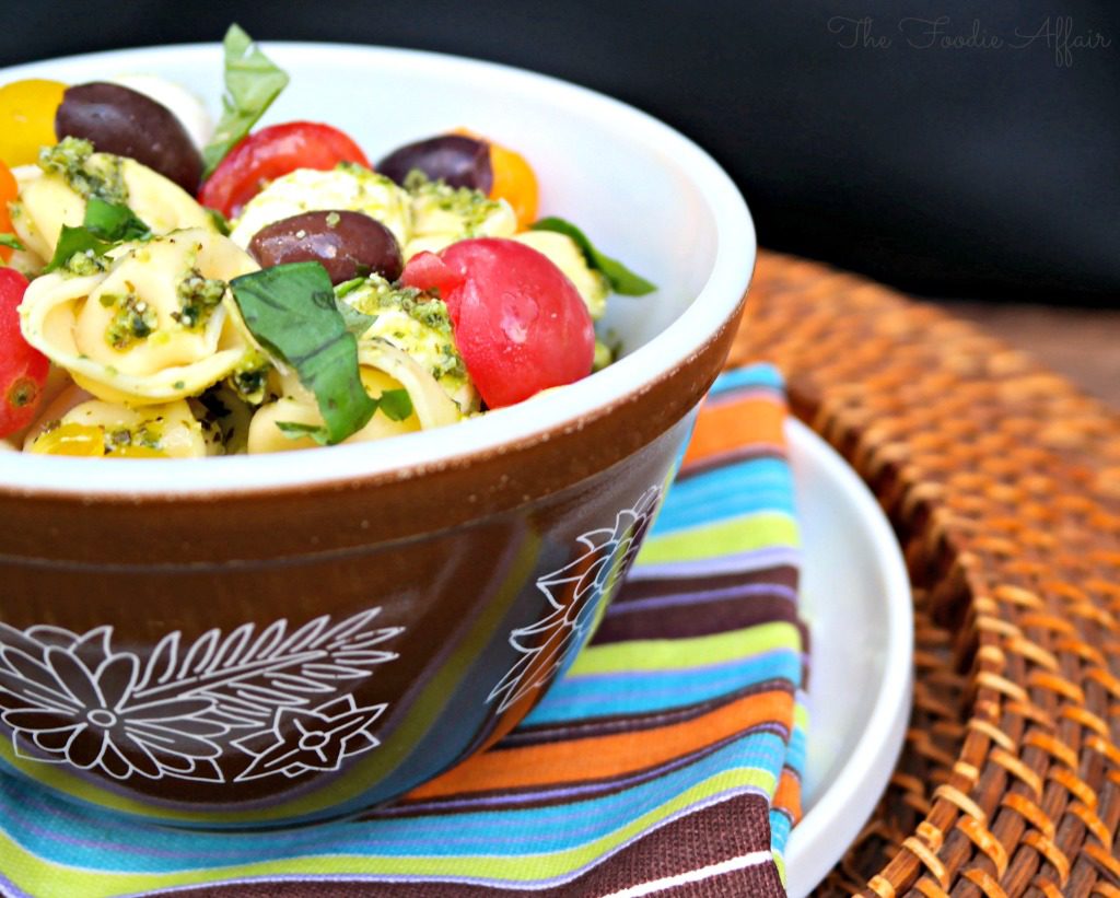 Tortellini Pesto Salad in a brown pyrex bowl.