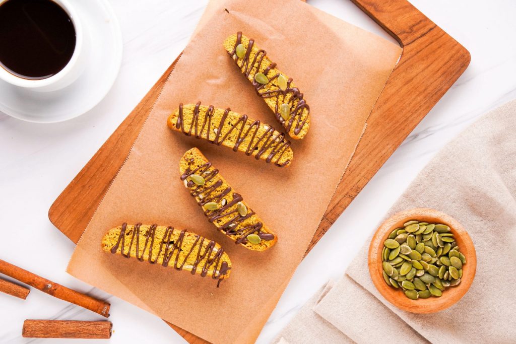 Drizzle of chocolate over biscotti on a wooden board. 