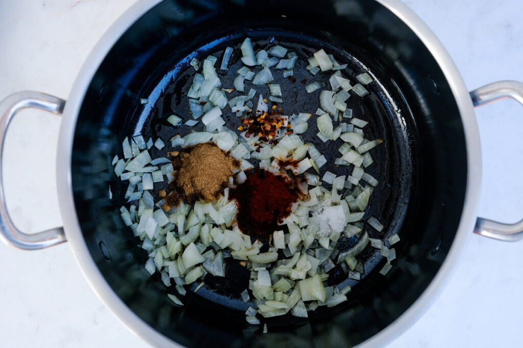 Diced onions and spices in a stock pot.