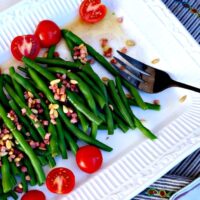 Fresh Green Beans with sliced tomatoes on a white platter
