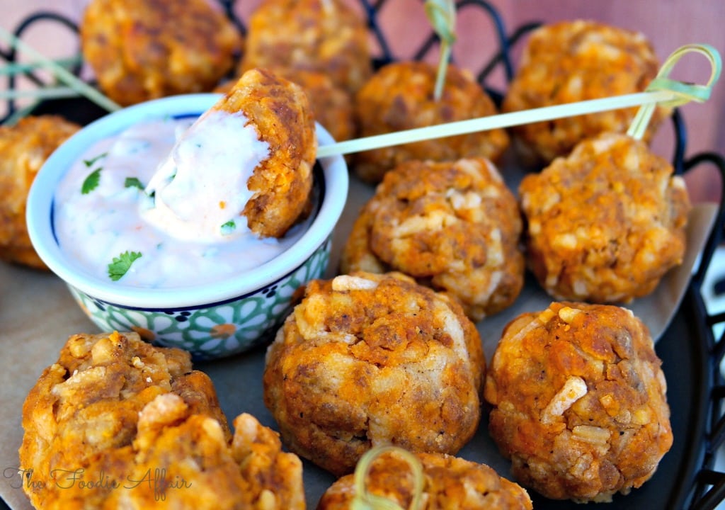 Soy Chorizo Cheddar Balls with a spicy dip in a small bowl 