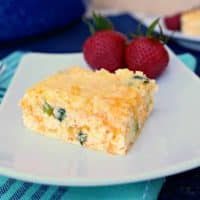 cheddar egg casserole on a white plate with strawberries