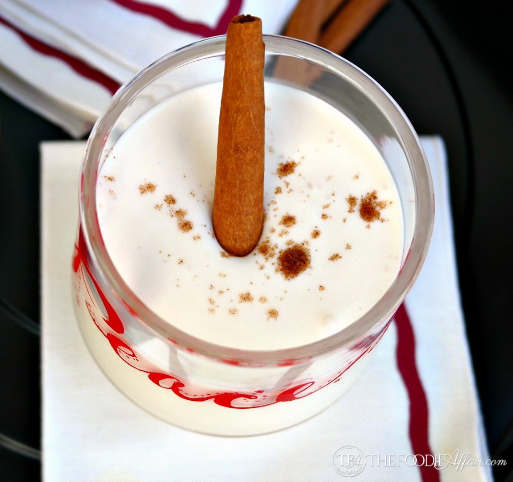 Coquito Cocktail in a clear glass topped with cinnamon