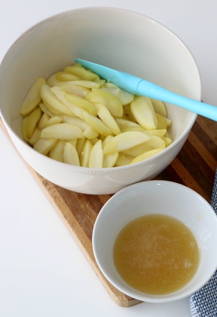 Apples in one bowl and sauce in another for the apple pie filling to freeze.
