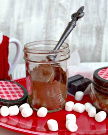 DIY hot cocoa mix in a glass mason jar with marshmallows on the side.